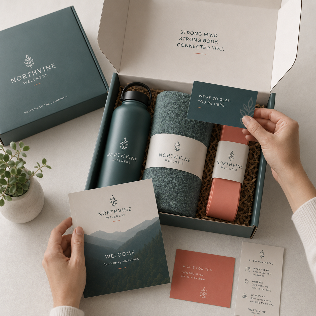 Northvine Wellness specialty welcome kit featuring a water bottle, towel, resistance band, and welcome guide in a custom branded box.